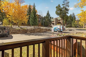 A parking area with a stone wall, a Jeep, and a van with a surveillance sign. - Walk to Lifts, Main St! (Breckenridge)