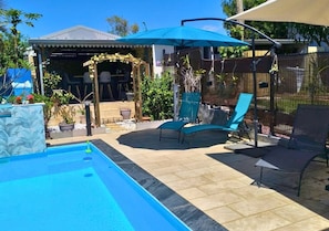 A swimming pool with lounge chairs and a covered seating area. - New Listing (Saint-André)