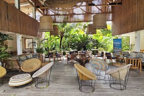 An outdoor seating area with wicker furniture and hanging light fixtures. - Flat "Zanzi Dream" at The Soul with Pool, balcony, AC (Paje)