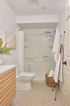 A bathroom with a toilet, shower, and a towel rack. - Brand New LakeHouse StrattCottage (Douro-Dummer)