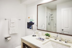 A modern bathroom with a large mirror, a shower, a toilet paper holder, and a small plant on the vanity. - Quiet Key West Base | Garden View, Poolside Bar & 1.9 Mi To Smathers Beach (Key West)