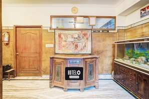 Ein Empfangsschalter mit einem 'HOTEL'-Schild, einer Uhr und einem Aquarium.