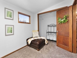 A bedroom with a bed, a wooden door, and a window. - A Stone's Throw | Steps to Lake Michigan (Gary)
