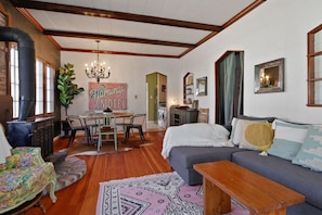 A cozy living room with a fireplace, a dining area, and a sofa with decorative pillows.