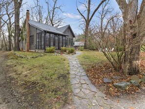 A log cabin with a stone pathway leading to the entrance. - Blackberry Cabin | Log Cabin w/ Hot Tub & Beach (Michiana)