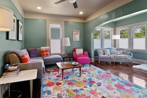 A living room with a sofa, armchairs, a coffee table, and a floral rug. - Cork Quarters | Historic Charm & Modern Comfort (Michigan City)