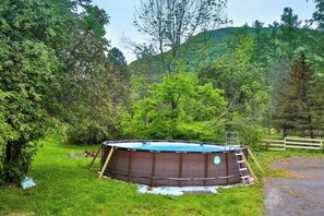 A swimming pool surrounded by lush greenery and a wooden fence. - 8Br 7Bath Sleeps 25+ Game hot tube 3 Min to MT (Hunter)