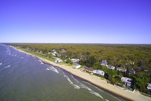 A coastal residential area with houses along the beach, clear skies, and a view of the ocean. - La Casita del Sol | Family Retreat Near the Lake (Michigan City)