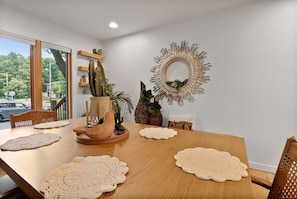 A dining area with a wooden table, crocheted placemats, and a cactus centerpiece. - La Casita del Sol | Family Retreat Near the Lake (Michigan City)