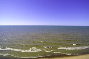 A beach with waves approaching the shore under a clear sky. - The Lake Hills Hideaway Newly Remodeled Beach Retr (Michigan City)