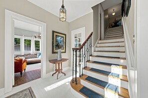 Un escalier avec des marches en bois et des balustrades noires, menant à l’étage supérieur.