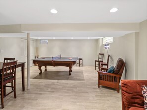 Ein Zimmer mit Pooltisch, Stühlen und einer Couch.
