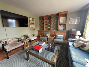 A living room with a television, books, and a coffee table. - Retro on Wabash, Vintage Vibes, Modern Comfort (Michigan City)