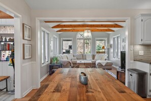 A spacious kitchen with a wooden floor, a dining table, and a built-in oven. - The Tree House | Lake Views & Beach a Block Away (Sawyer)