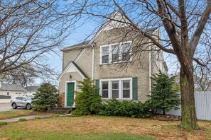 A two-story house with a green door, white shutters, and a small front porch. - Downtown Anoka 2BR Steps to Shops & Rum River (Anoka)