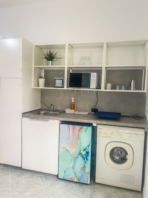 A compact kitchen with a dishwasher, microwave, and a washing machine. - New Listing (Gela)