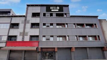 A modern hotel building with a sign that reads 'HOTEL' and 'Company-Serviced.'