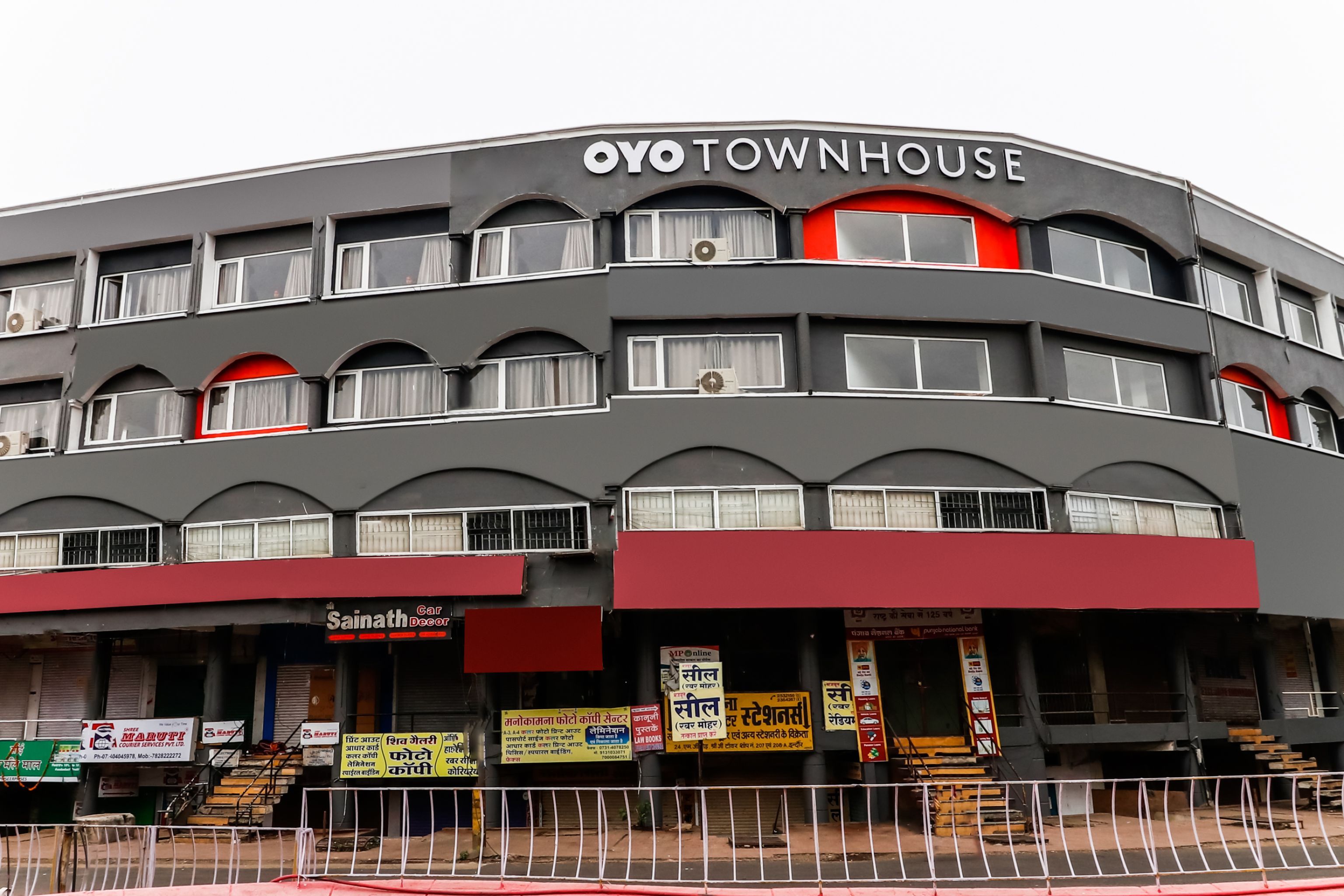 A multi-story building with the sign 'OYO TOWNHOUSE' at the top.