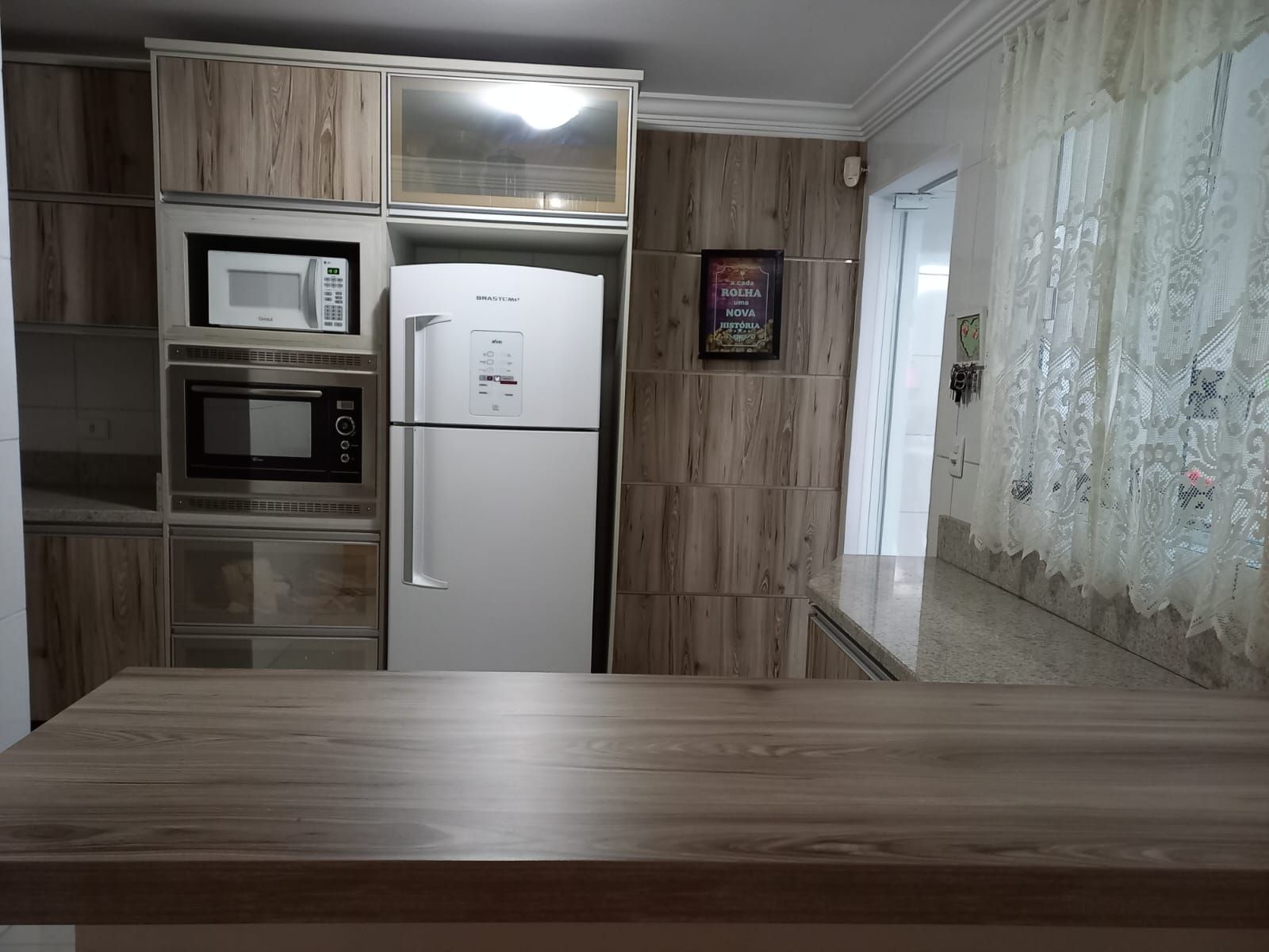A kitchen with built-in appliances, including a microwave, oven, and refrigerator.