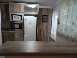Eine Küche mit integrierten Geräten, darunter eine Mikrowelle, ein Backofen und ein Kühlschrank.