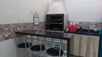 A kitchen with a built-in oven, a sink, and a bar stool area.