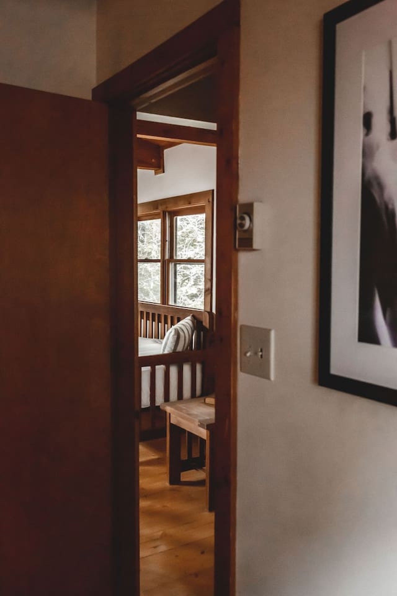 Una porta in legno che dà su una stanza con una panca e una finestra.