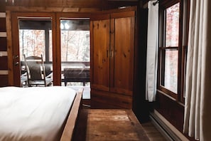 Une chambre à coucher en bois, avec un lit, une armoire en bois et une fenêtre avec des rideaux.