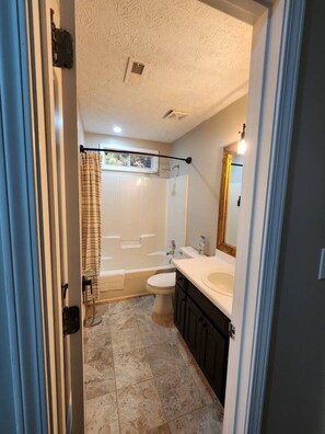 Un baño con bañera, inodoro y lavamanos.