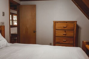 Ein Schlafzimmer mit einem Bett, einem Holzschrank und einer Tür.