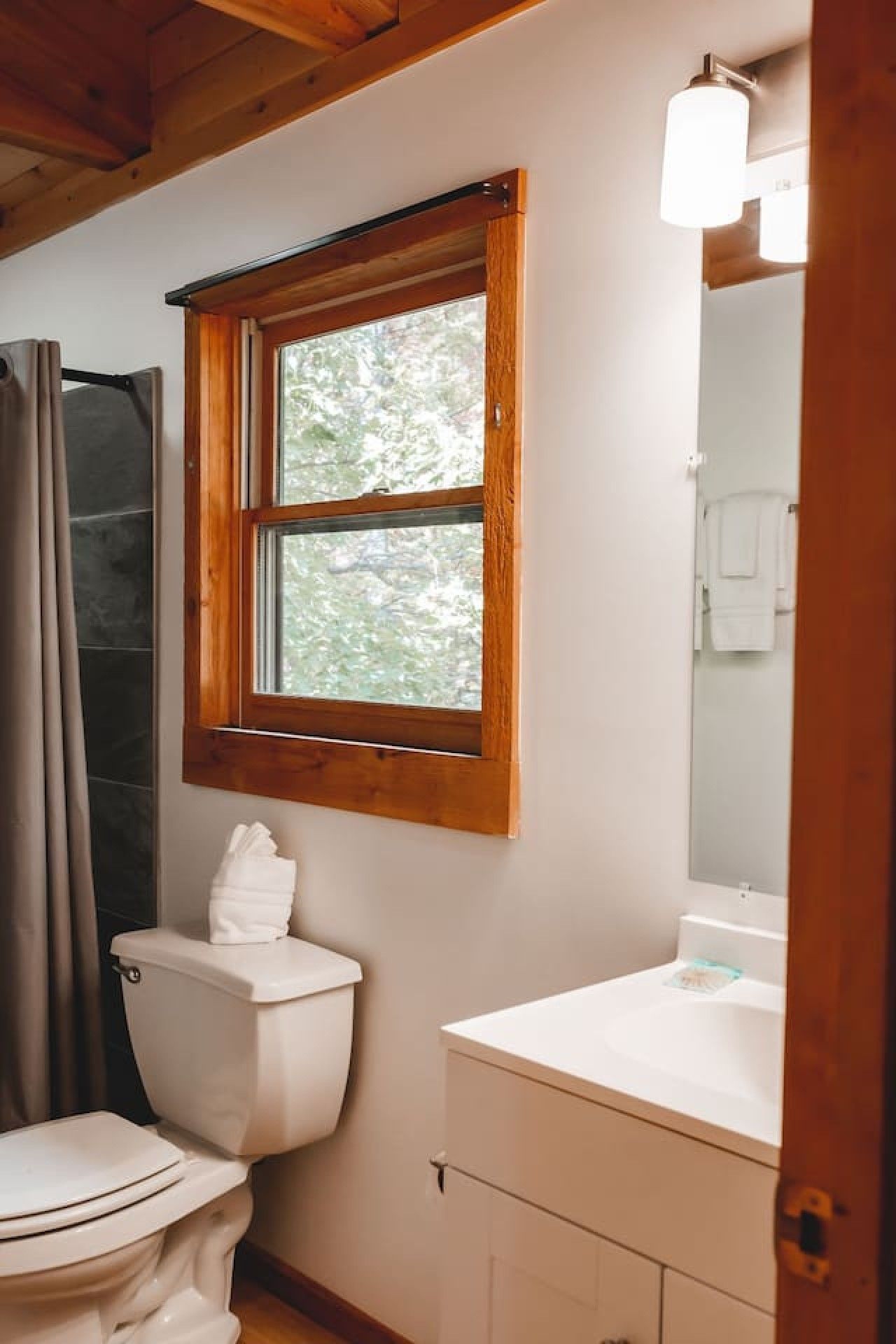 Une salle de bain avec des toilettes, une fenêtre et un lavabo.
