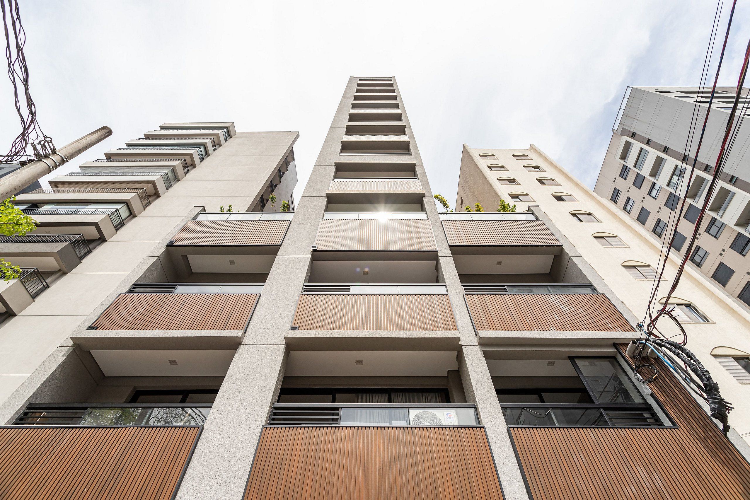 Un edificio de varios pisos con un diseño arquitectónico moderno, que cuenta con balcones y una fachada uniforme.