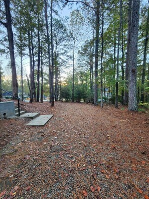 A forested area with a gravel path and a concrete slab. - The Quiet Studio, lux apartment, in central area. (Newnan)