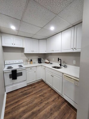 A kitchen with white cabinets, a stove, a sink, and a dishwasher. - The Quiet Studio, lux apartment, in central area. (Newnan)