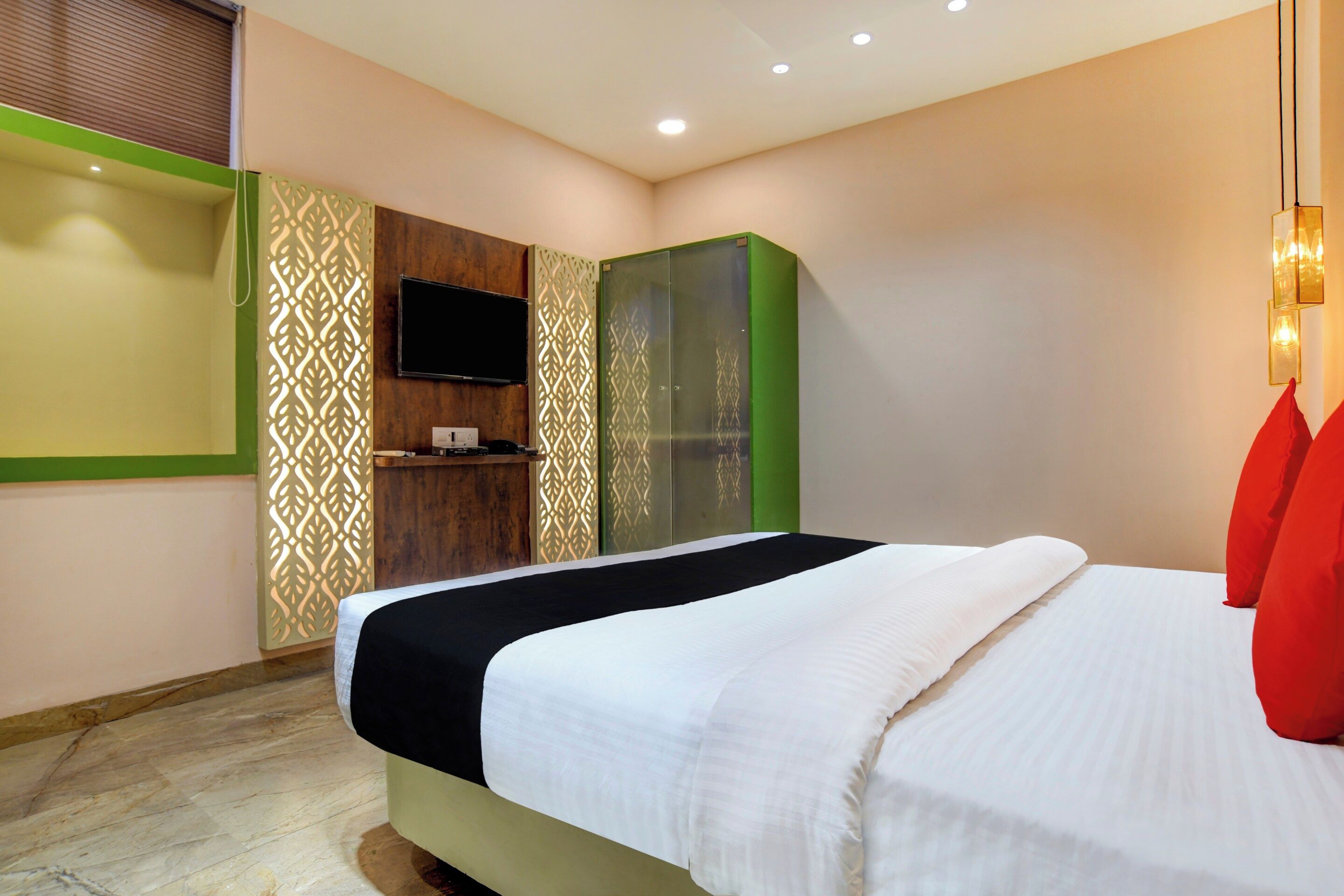 Habitación de hotel con cama, televisor y armario.