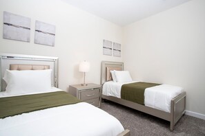 Ein Hotelzimmer mit zwei Betten, einem Nachttisch und einer Lampe.