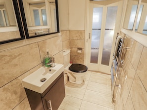 A bathroom with a toilet, sink, and mirror. - Apartment 173 (Lincoln)