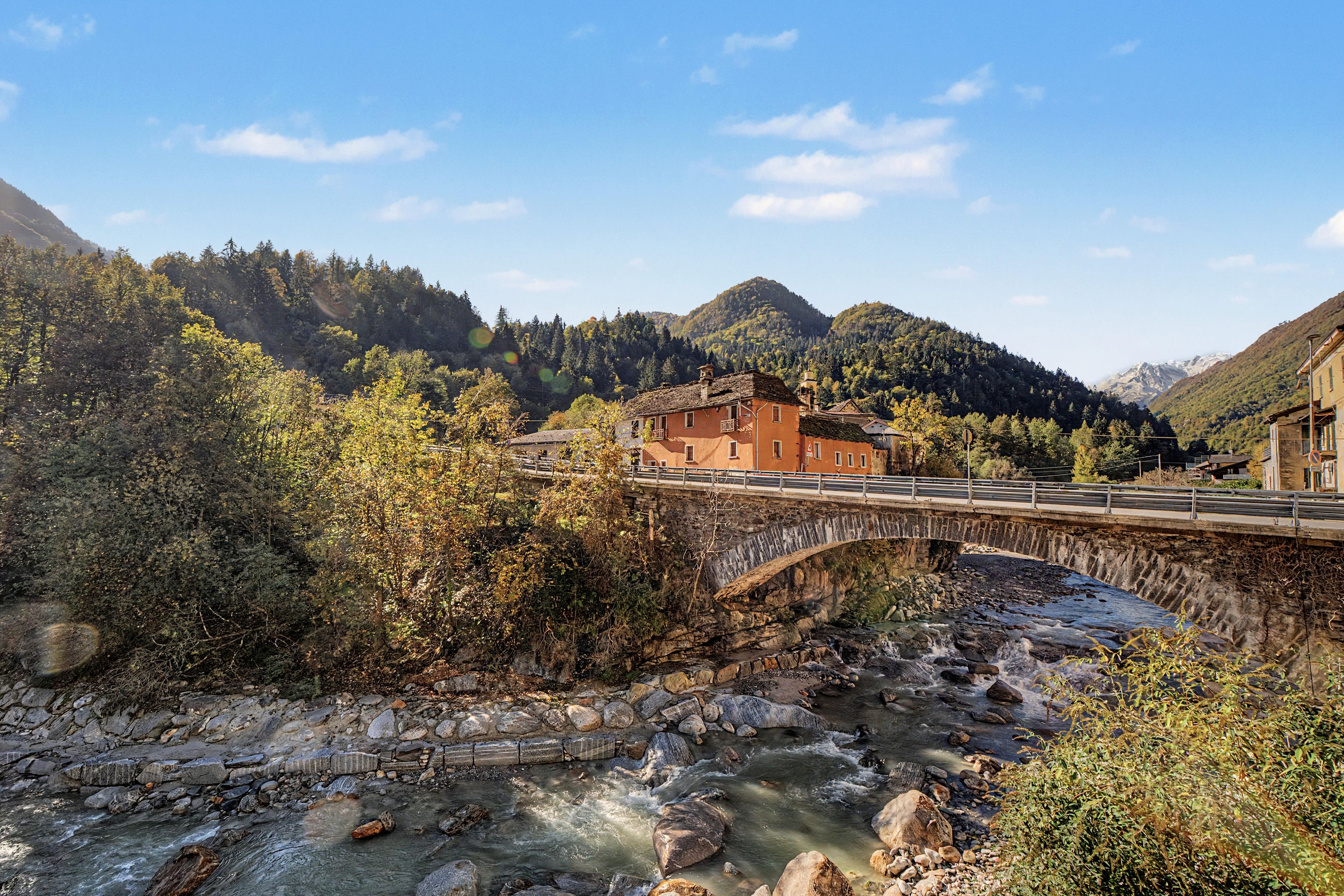 Un ponte di pietra che scavalca un fiume, con un edificio sulla destra.