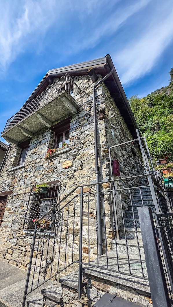 Un edificio de piedra con un balcón y una escalera que lo lleva.