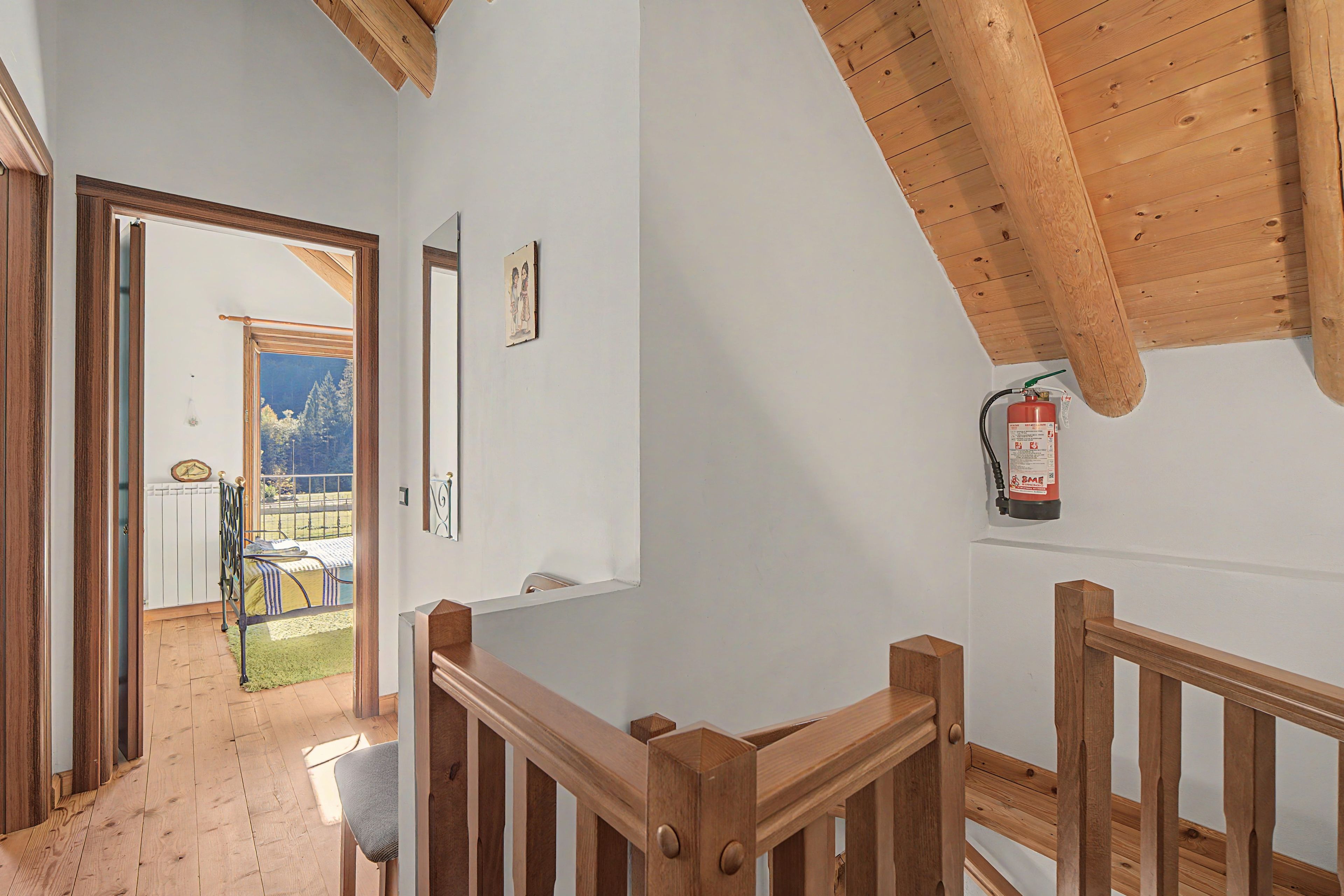 Un escalier en bois avec un extincteur fixé au mur.