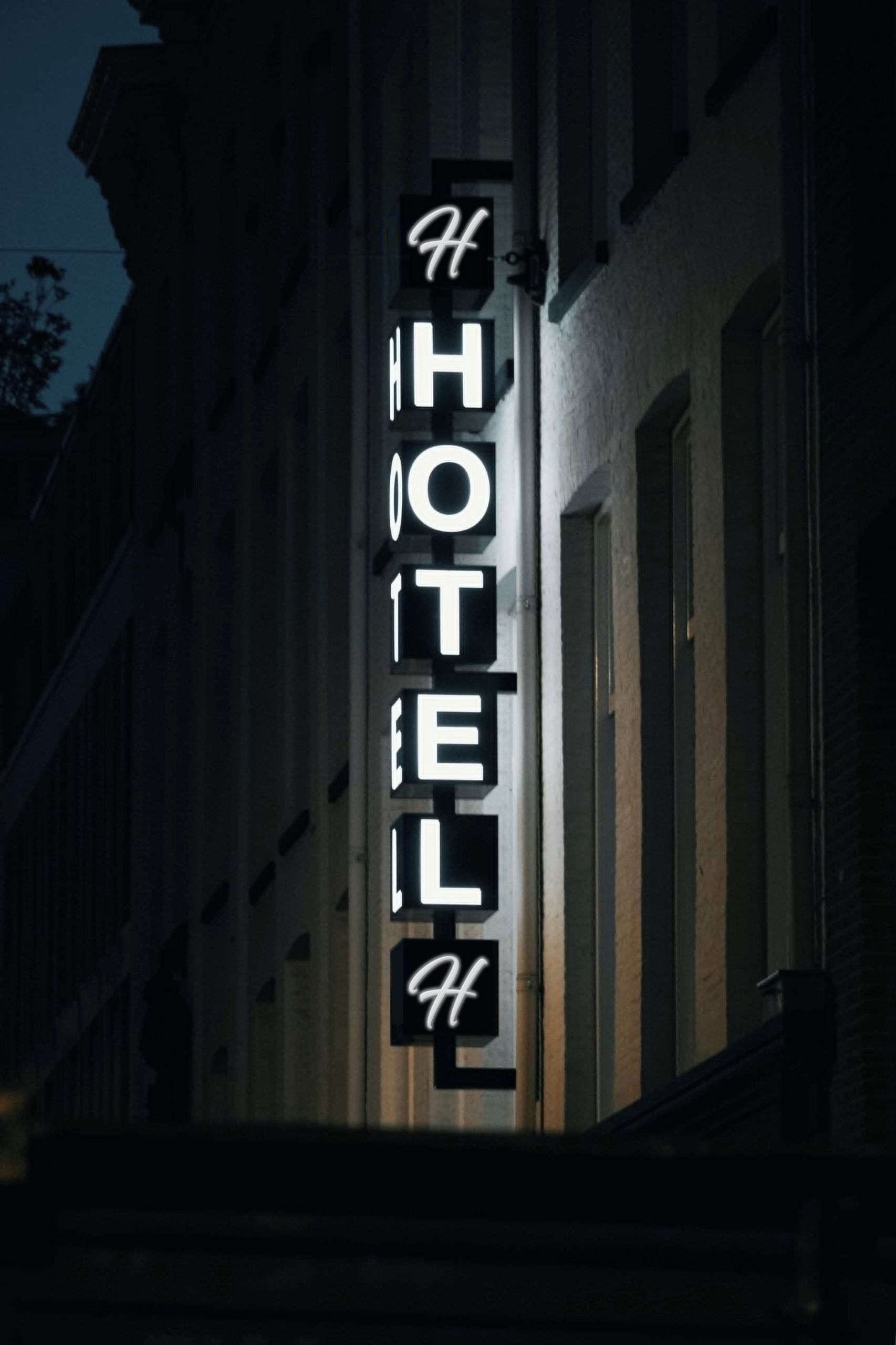 A hotel sign with the name 'HOTEL' in capital letters, mounted on a building facade.