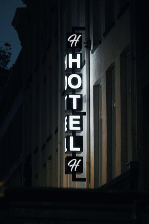 Un letrero de hotel con el nombre 'HOTEL' en letras mayúsculas, colocado en la fachada de un edificio.