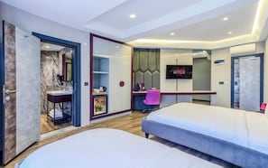 A modern hotel room with a bed, a desk, a TV, and a bathroom. - Heaven Prime Airport Hotel (Arnavutkoy, Turkiye)
