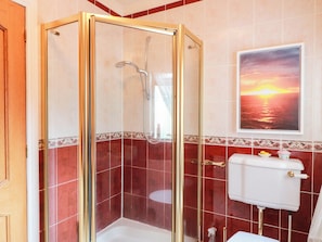 Une salle de bain avec une douche à parois de verre, des toilettes et un lavabo.