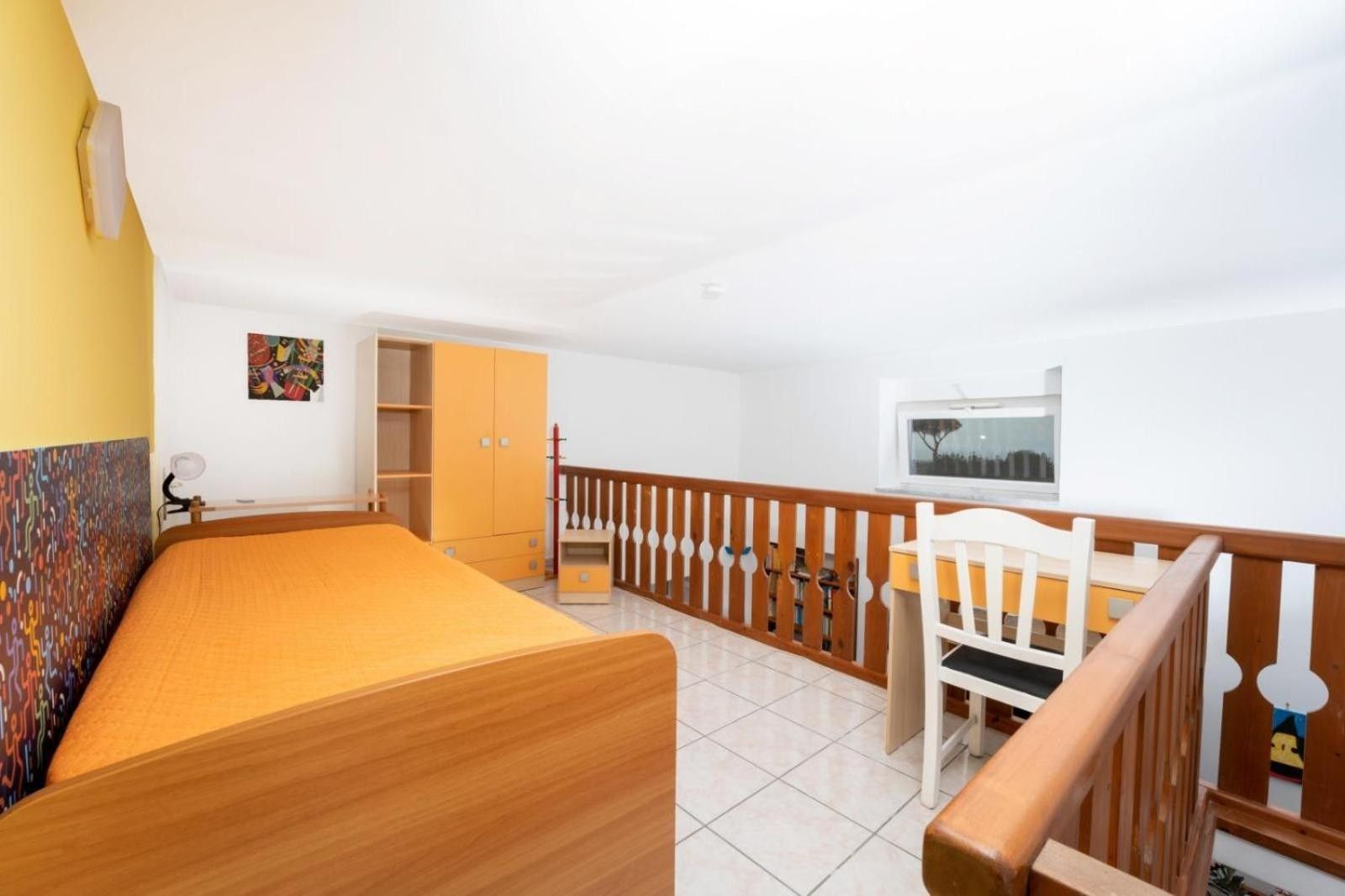 Un dormitorio con cama, armario y ventana.