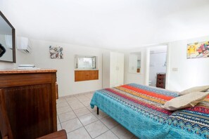 A bedroom with a bed, a wooden dresser, a window, and a door. - A corner of paradise in Anacapri with a private sea-view sun terrace (Anacapri)