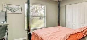 A bedroom with a bed, a window with blinds, a door, and a wall-mounted artwork. - Paradise Preserve (Rotonda West)