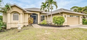 A single-story house with a front porch, a garage, and a small garden with a fountain. - Paradise Preserve (Rotonda West)