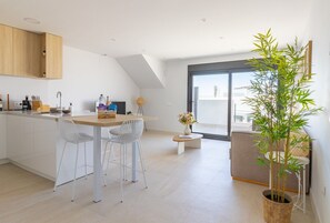 A modern kitchen with a dining area, a large window, and a bamboo plant. - Alma Rosa - modern appartement met 80 m2 prive dakterras (Torrevieja)