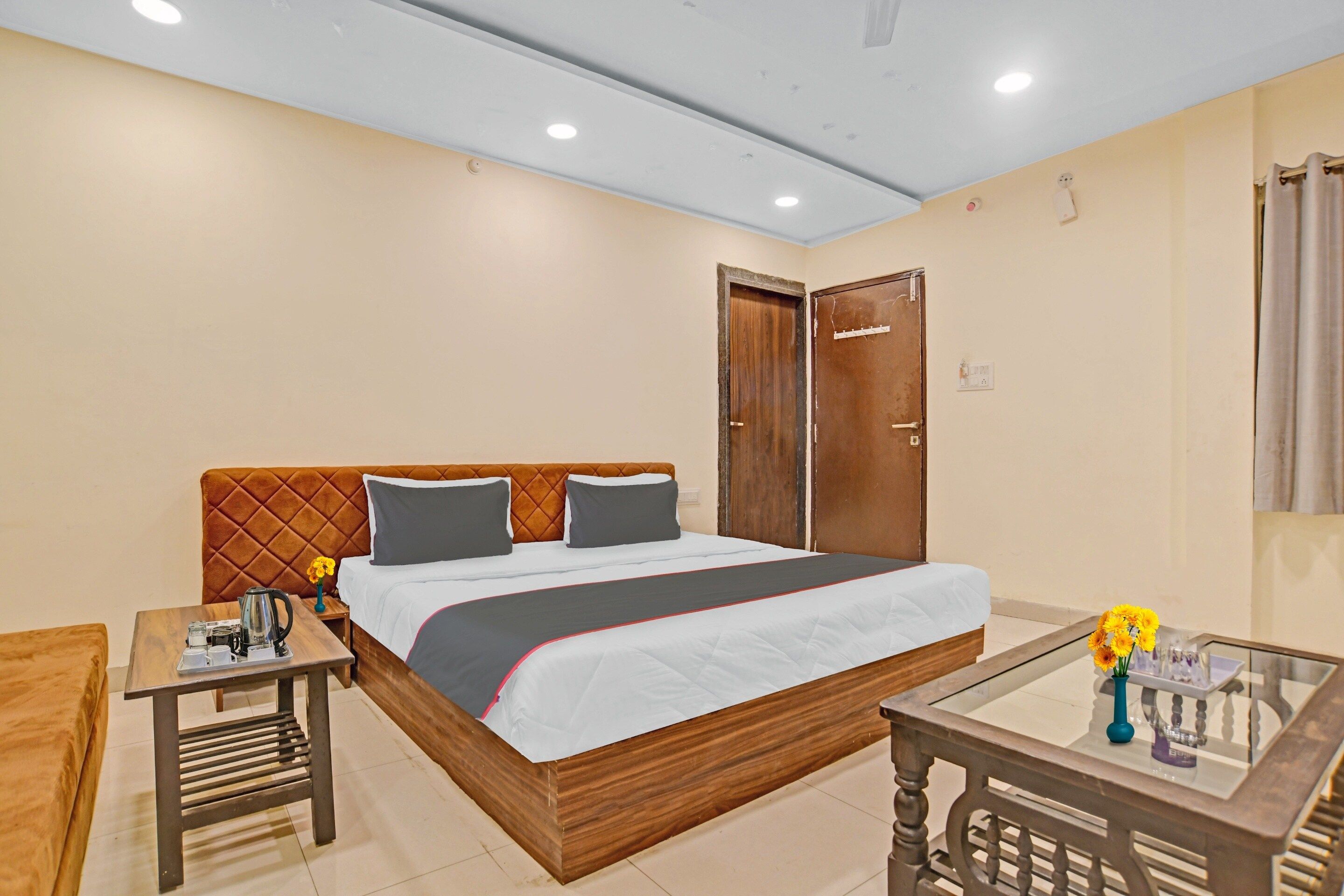 Una habitación de hotel con cama, mesita de noche, pequeña mesa y silla.