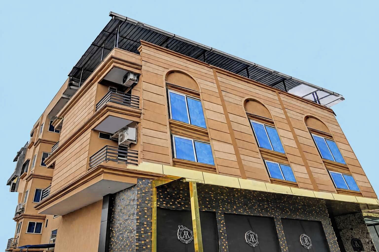 A multi-story building with balconies, large windows, and a flat roof.